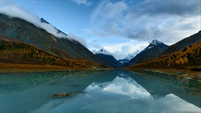 Time Lapse. Belukha Mountain and Highland Lake Akkem in autumn sunset. Altay Mountains, Russia.