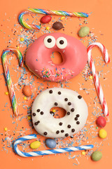 Funny glazed donuts on orange background
