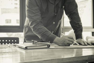 Man holding yellow helmet with documents.
