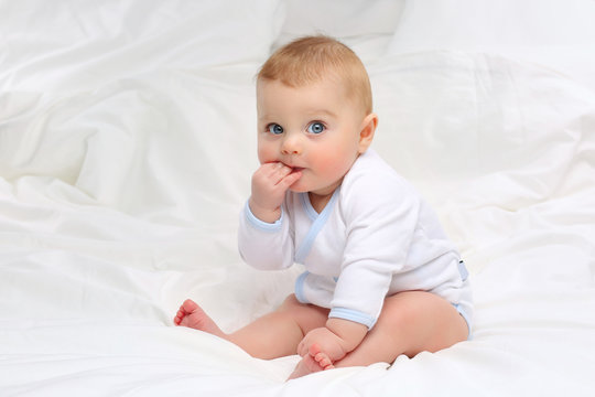 Baby in white bedding.