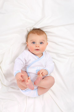 Baby in white bedding.