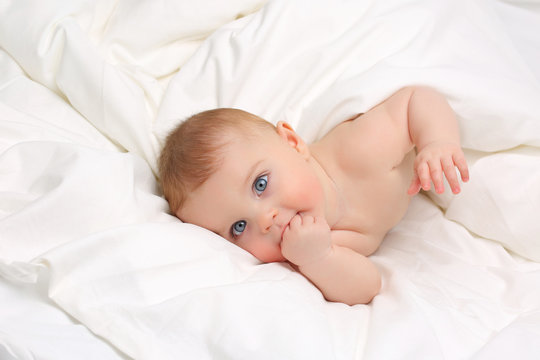 Baby in white bedding.