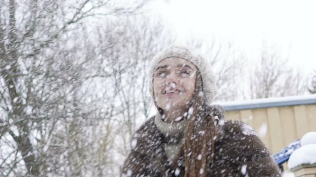 Pretty girl enjoying of snow falling. Slow motion