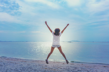 Young lady jumping on the beach , feeling happy and fun , color effect