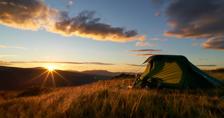 A hiker camping on the mountain summit of Place Fell in the Lake District. UK - obrazy, fototapety, plakaty