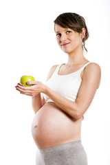 Pregnant woman isolated over white background, holding apple.