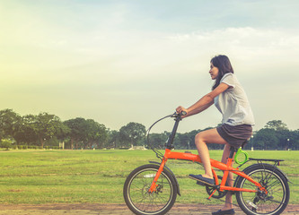 Fototapeta na wymiar young woman riding a bicycle in a park., healthy lifestyles