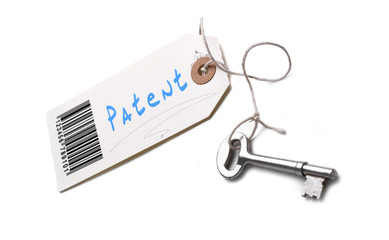 A silver key with a tag attached with a Patent concept written o