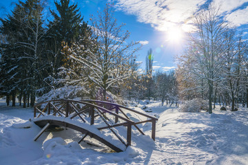 Wooden bridge covered by fresh snow in winter park