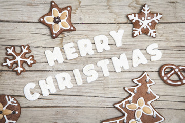 Weihnachtlicher grauer Holz Hintergrund mit Lebkuchen und Merry Christmas