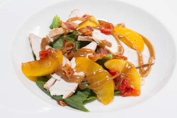 Tasty dinner. Green salad with chicken, bacon, peach