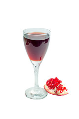 Pomegranate juice in a wine glass and ripe pomegranate