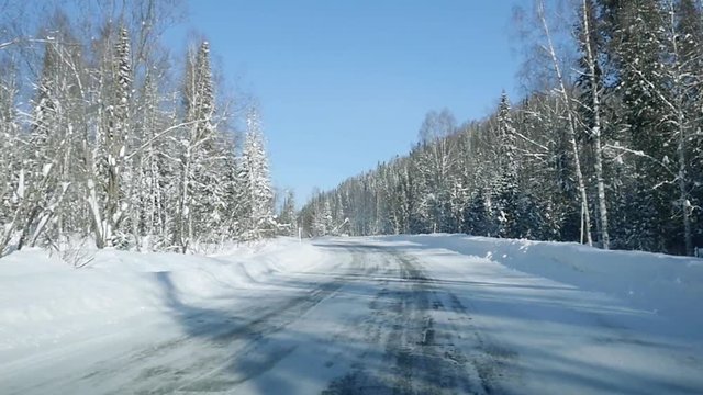 Winter landscape with road at forest and the blue sky in slowmotion. 1920x1080