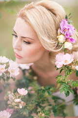 Fototapeta premium Beautiful Blonde Bride in White Dress with Flowers in her hairst