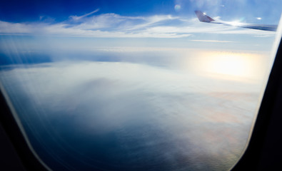 Clouds and sky as seen through window of an aircraft