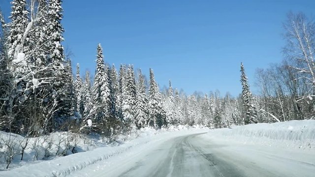 Winter landscape with road at forest and the blue sky in slowmotion. 1920x1080