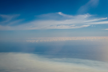 Aerial photo of land and clouds from above.