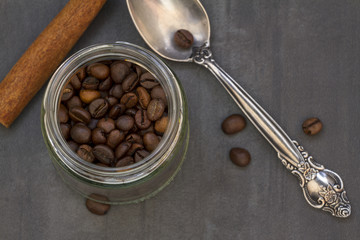 Closeup of freshly roasted coffee beans with a spoon in a glass