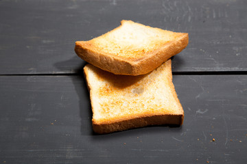Toast the bread on a black wooden background