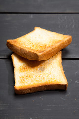 Toast the bread on a black wooden background