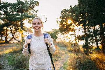 young woman traveler with backpack in the forest