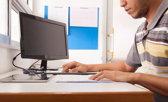 Doctor working with computer at desk in the hospital