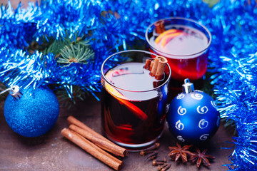 Hot mulled wine with spices and blue garland 