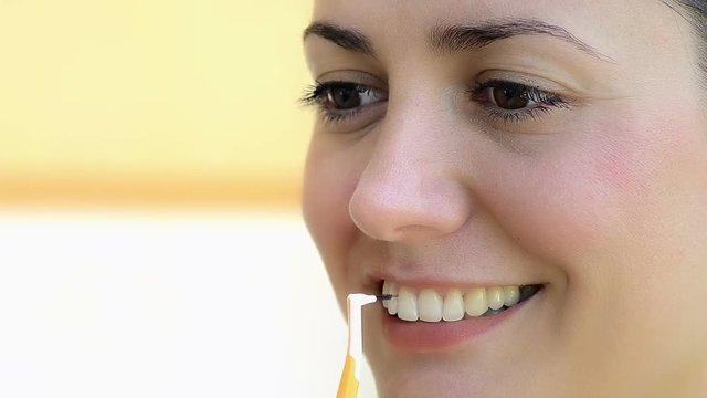 Young woman using interdental brush