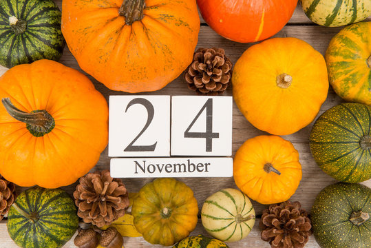 Date 24 november, thanksgiving, surrounded by pine apples and orange and green pumpkins