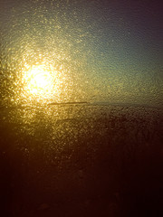 Fototapeta na wymiar Drops on the window with morning sun in backlight