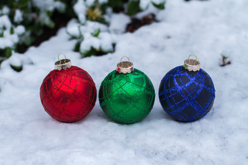 RGB Christmas balls on snowy ground