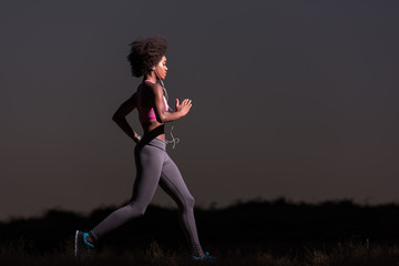 Fototapeta na wymiar Young African american woman jogging in nature