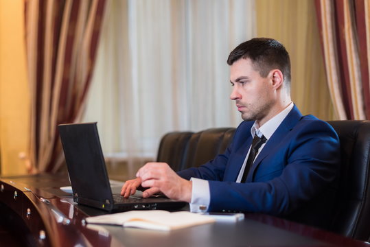Business man in Office with laptop.