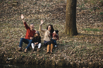 family resting on the river bank