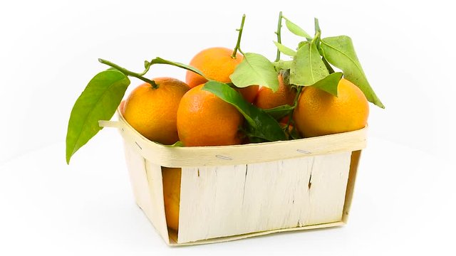 Tangerines with leaves in basket rotates in loop