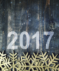 Happy New Year 2017 on a  wooden background. Number 2017 on vintage style wooden texture background. Snowflakes on a wooden board. 