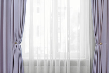 Room window with white and grey curtains, close up