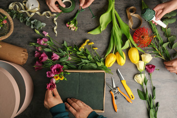 Vrouwelijke handen die mooie bloemsamenstelling maken in bloemenwinkel
