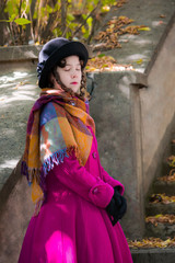 Obraz premium Portrait girl in a bright crimson coat with eyes closed.