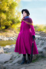 girl in a bright crimson coat looks into the distance