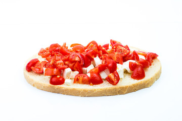 Fresh Italian bruschetta with roasted tomatoes, mozzarella cheese, olive oil and basil and oregano herbs on white background