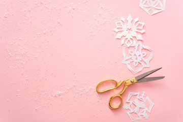 christmas theme. paper snowflkes on pink table