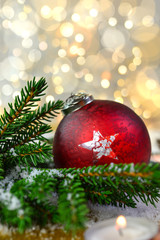 Rote Weihnachtskugel mit Tannenzweigen und goldenem Hintergrund