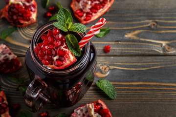 Glasses of pomegranate juice with fresh pomegranate fruits