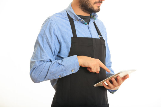 Young man with black apron taking an order