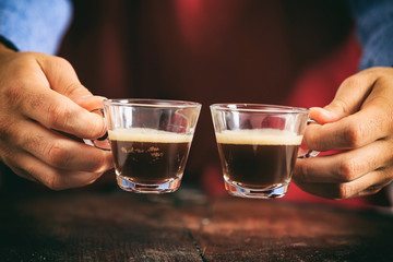 Barista holding two espresso cups