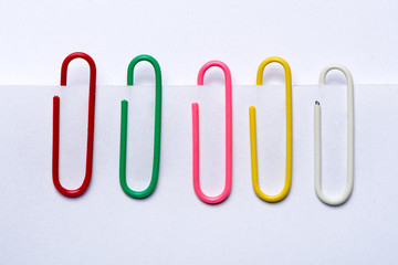 Set of colorful paper clips attached to sheets of paper.