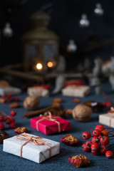 Christmas gifts, rowan, nuts, old lamp on dark surface