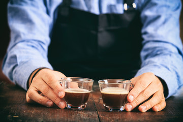 Barista holding two espresso cups