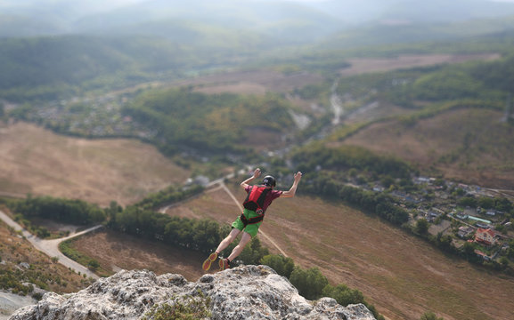 man jumps from the cliff in mountains